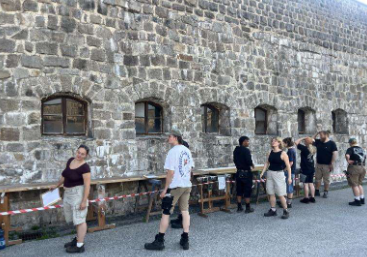 Menschen stehen vor einer Wand mit Fenstern.